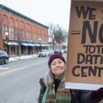 Modern data center server racks with glowing lights, symbolizing digital infrastructure and its environmental footprint.