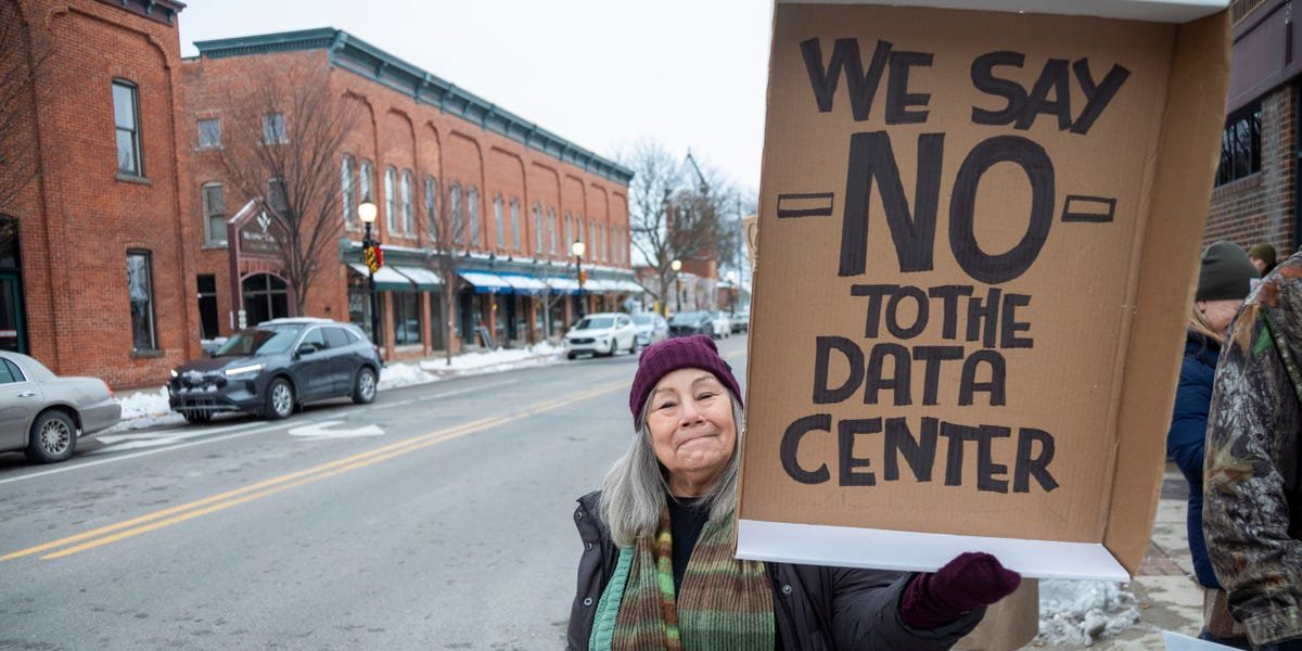 Modern data center server racks with glowing lights, symbolizing digital infrastructure and its environmental footprint.