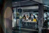 A leader observing their team's work intently, perhaps with a football field in the background, symbolizing direct engagement.