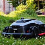 Le robot tondeuse Dreame A3 AWD Pro 3500 en action sur une pelouse verte, mettant en avant son design robuste et ses capacités tout-terrain.