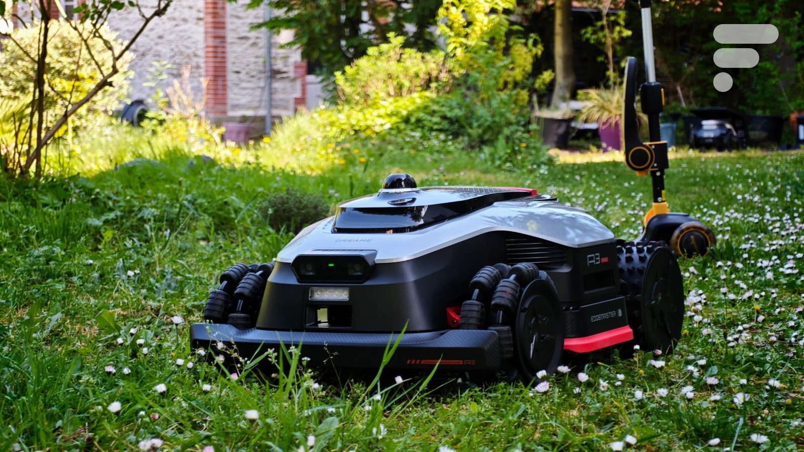 Le robot tondeuse Dreame A3 AWD Pro 3500 en action sur une pelouse verte, mettant en avant son design robuste et ses capacités tout-terrain.