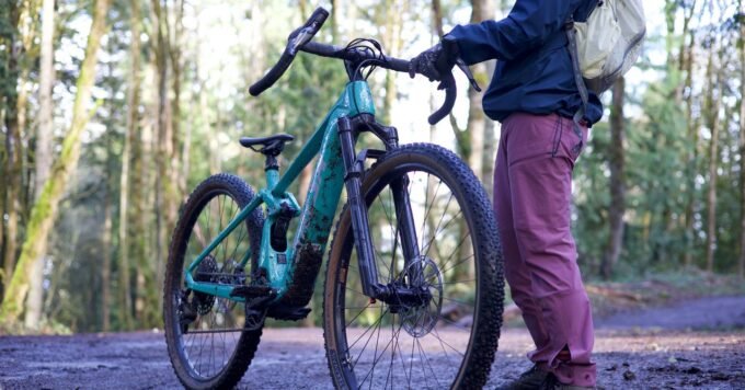 A skilled mechanic carefully inspecting the motor of an electric bicycle on a repair stand.