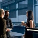 A diverse group of professionals collaborating with kindness and empathy in a modern office setting, symbolizing positive business relationships.