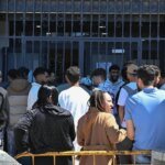 Une file d'attente de personnes devant un consulat marocain en Espagne, illustrant l'afflux de demandes de régularisation.