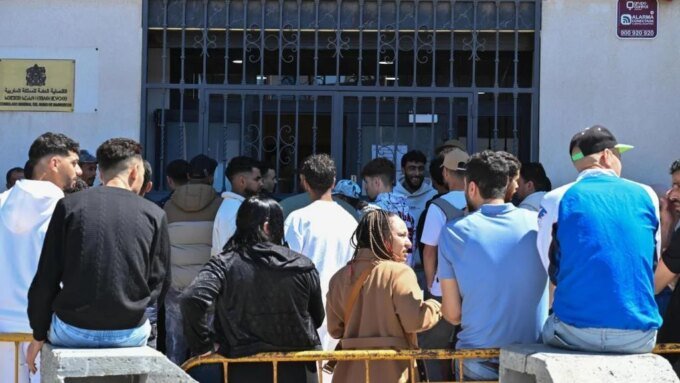 Une file d'attente de personnes devant un consulat marocain en Espagne, illustrant l'afflux de demandes de régularisation.