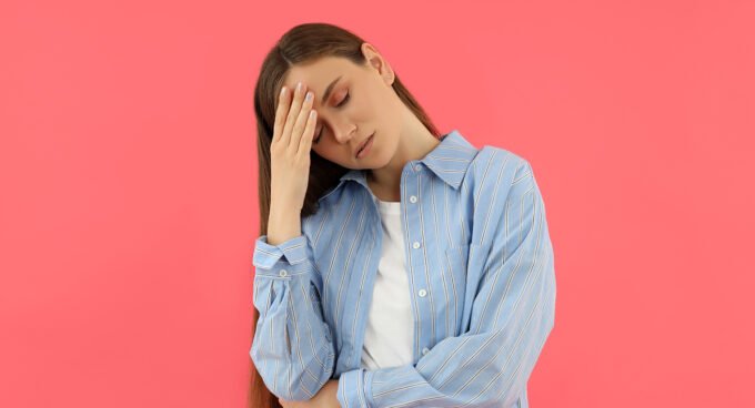 Une personne fatiguée buvant un verre d'eau, symbolisant l'importance de l'hydratation pour retrouver de l'énergie et combattre la déshydratation.