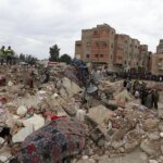 Image d'un immeuble effondré à Fès, avec des débris et des équipes de secours.