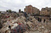 Image d'un immeuble effondré à Fès, avec des débris et des équipes de secours.