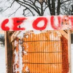 An anti-ICE sign displayed prominently outside a house in a Minneapolis neighborhood, symbolizing local opposition to immigration enforcement.