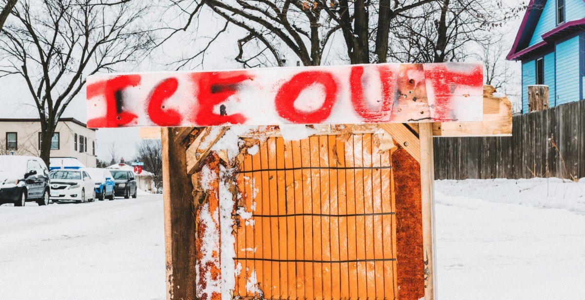 An anti-ICE sign displayed prominently outside a house in a Minneapolis neighborhood, symbolizing local opposition to immigration enforcement.