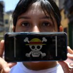 A young person (Gen Z) looking at financial charts on a laptop, surrounded by symbols of money, debt, and digital currency.