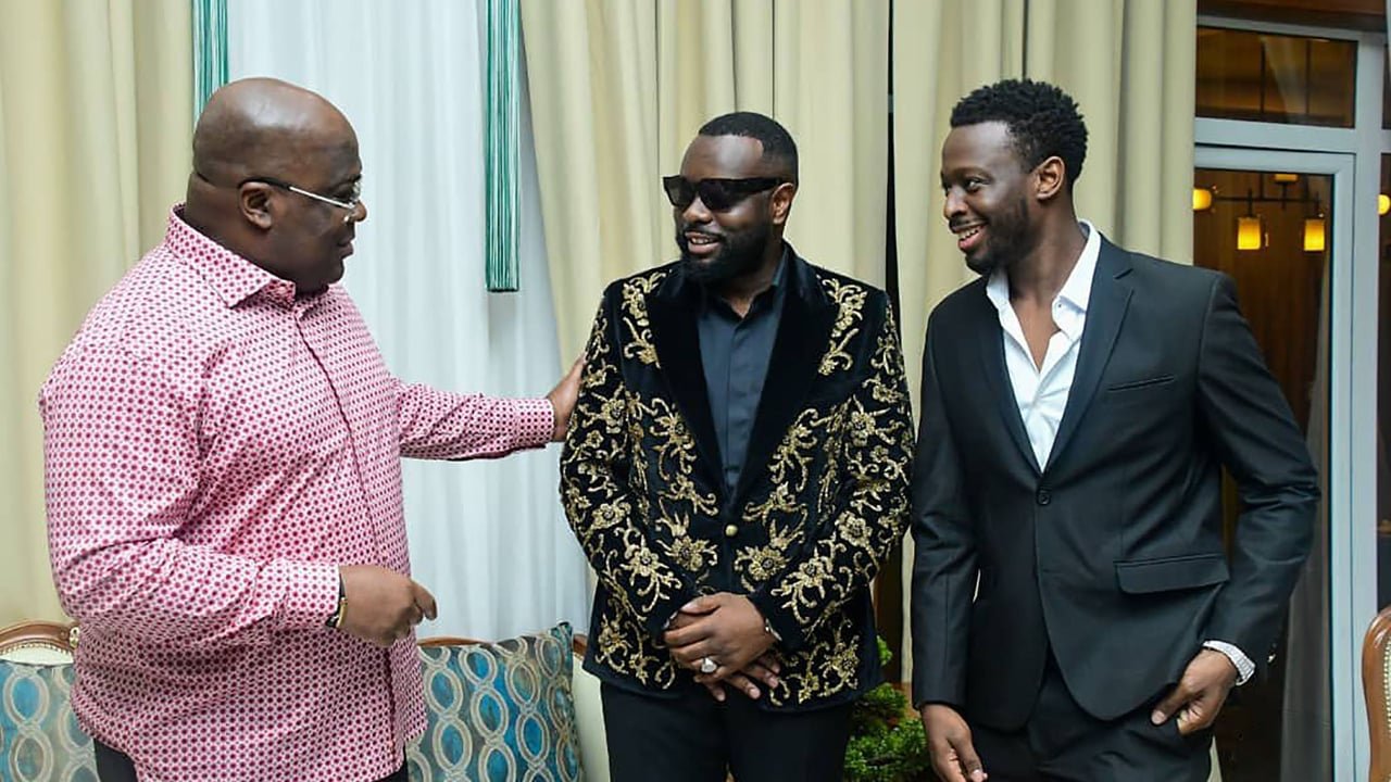Le musicien Gims et son frère Dadju posent aux côtés du président Félix Tshisekedi au palais présidentiel de Kinshasa, en République Démocratique du Congo, le 30 janvier 2022.