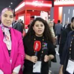 Des visiteurs du GITEX interagissant avec des innovations technologiques sur un stand d'exposition animé.