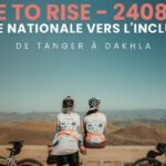 Deux cyclistes, dont Aziza Gannoune, devant un paysage marocain, symbolisant leur parcours de 2408 km pour l'inclusion des personnes handicapées.