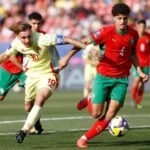 Ismaël Baouf, jeune défenseur central des Lions de l'Atlas, en pleine action sur un terrain de football, symbolisant son potentiel pour le Mondial 2026.