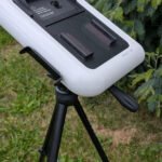 Un enfant de 8 ans observe le ciel à travers le télescope Vaonis Hestia, avec un smartphone fixé sur l'appareil.