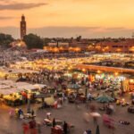 Le Maroc en 2026 : Tourisme en plein essor et transferts MRE robustes, malgré un recul des IDE 8 Vue aérienne d'une plage marocaine ensoleillée avec des touristes profitant du sable fin et de la mer turquoise, symbolisant l'essor du secteur touristique.