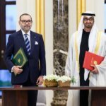 Drapeaux du Maroc, de l'Arabie Saoudite et des Émirats Arabes Unis flottant ensemble, symbolisant leur alliance stratégique face aux défis sécuritaires régionaux.