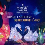 Vue aérienne du Vélodrome d'Anfa transformé en jardin lumineux féérique avec des installations d'art immersif et des projections lumineuses colorées, des familles se promenant dans l'allée principale.