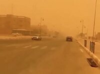 Une tempête de sable balayant le sud du Maroc, réduisant la visibilité sous un ciel orangé.