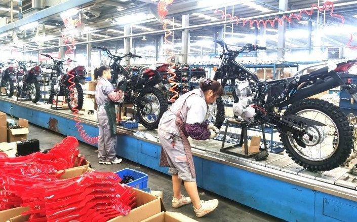 Motos : les marques chinoises se donnent cinq ans pour reproduire le raz-de-marée mondial des voitures 3 Une moto moderne de marque chinoise roulant sur une route, symbolisant l'ambition et la vitesse d'expansion sur le marché mondial.