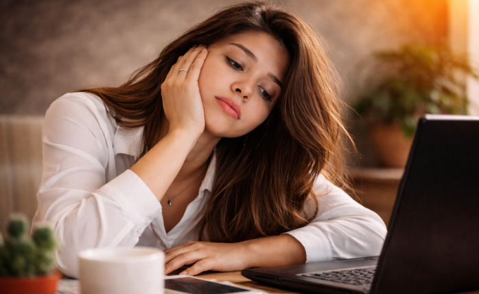 A person looking inspired and focused, perhaps journaling or working on a laptop in a bright, organized space.