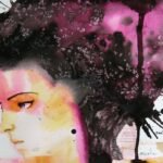 A person looking thoughtfully at a sunrise over mountains, symbolizing hope and overcoming challenges.