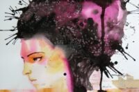 A person looking thoughtfully at a sunrise over mountains, symbolizing hope and overcoming challenges.