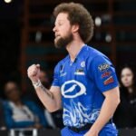 A professional bowler celebrating a strike, with a Wendy's logo subtly in the background representing their past.