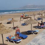 Une plage marocaine propre avec des eaux claires et le drapeau Pavillon Bleu flottant au vent.
