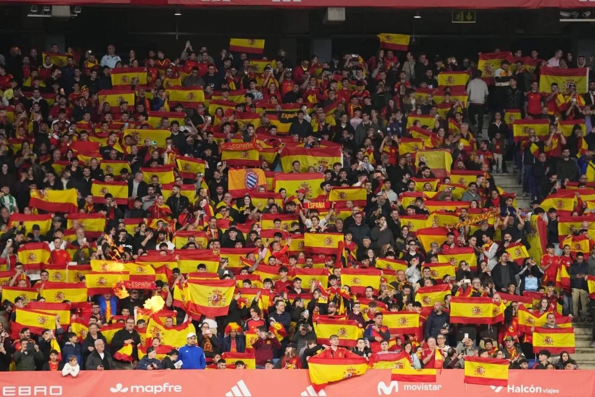 Des supporters dans un stade de football, avec une ambiance tendue ou des bannières. L'image doit évoquer la foule et le contexte sportif.