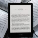 A refurbished 2021 Kindle Paperwhite e-reader displaying text on its screen, highlighting the device's sleek design and readability.