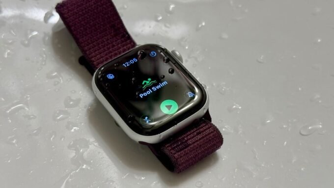 A smartwatch partially submerged in water, illustrating water resistance