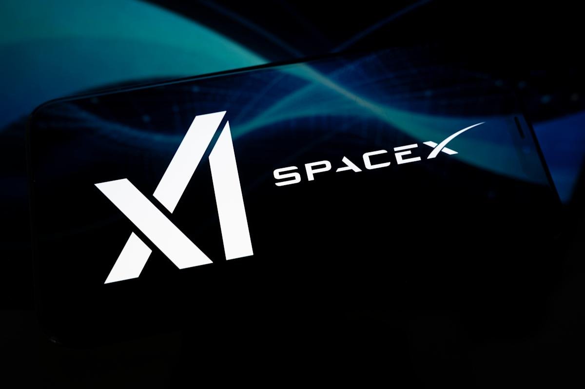 Smartphone screen displaying xAI and SpaceX logos, reflecting an abstract black and blue illustration.