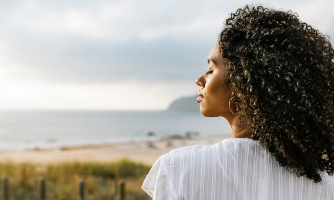 Person meditating or in a peaceful state, symbolizing surrender and spiritual connection, perhaps with light emanating around them.