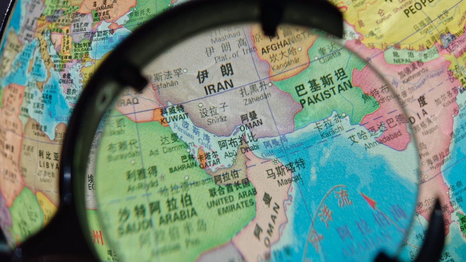 China Slams U.S. Strait of Hormuz Blockade as 'Dangerous and Irresponsible' 3 A large oil tanker navigating the narrow Strait of Hormuz, with a naval vessel in the background, symbolizing geopolitical tensions and critical trade routes.