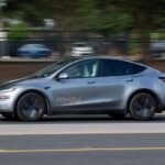 Tesla robotaxis driving autonomously on a city street in Texas.