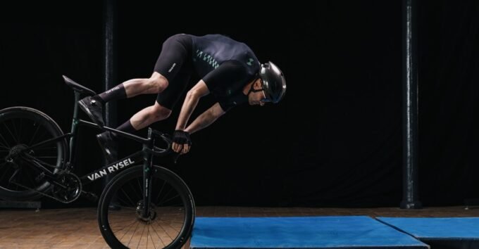 A lightweight Van Rysel skinsuit with an integrated airbag deploying to protect a cyclist's upper body.