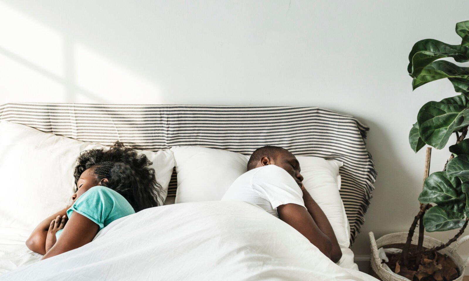 A person lying awake in bed at night, looking stressed, contemplating relationship issues, symbolizing the link between anxious attachment and sleep disturbance.