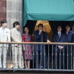 صورة لفرقة BTS على شرفة القصر الوطني في مكسيكو سيتي، مع حشد ضخم من المعجبين في ساحة زوكالو.