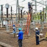 Des agents d'Eneo effectuant des travaux d'entretien au poste de transformation électrique de Songloulou, symbolisant les défis et les espoirs du secteur énergétique camerounais.