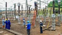 Des agents d'Eneo effectuant des travaux d'entretien au poste de transformation électrique de Songloulou, symbolisant les défis et les espoirs du secteur énergétique camerounais.