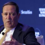 Cisco CEO Chuck Robbins speaks at a summit, symbolizing the company's strategic direction amidst AI-driven growth and workforce restructuring.