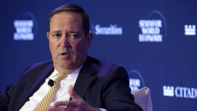 Cisco CEO Chuck Robbins speaks at a summit, symbolizing the company's strategic direction amidst AI-driven growth and workforce restructuring.