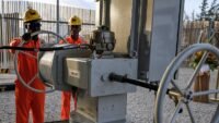 Deux employés du géant italien de l’énergie Eni à Port-Bouët, le 23 novembre 2023, symbolisant l'activité pétrolière en Côte d'Ivoire.