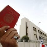 متظاهر بحريني يرفع جواز سفر خلال احتجاج في المنامة ضد سياسات التجنيس.