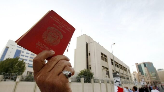 متظاهر بحريني يرفع جواز سفر خلال احتجاج في المنامة ضد سياسات التجنيس.