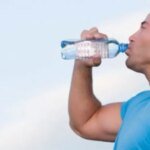 صورة توضيحية لشخص يشعر بالتعب أو الصداع، مع التركيز على أهمية شرب الماء والسوائل للحفاظ على ترطيب الجسم وتجنب الجفاف.