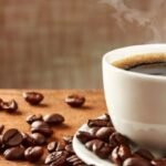 صورة لكوب قهوة بجانب مجسم للكلى، ترمز إلى العلاقة بين القهوة وصحة الكلى