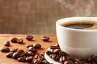صورة لكوب قهوة بجانب مجسم للكلى، ترمز إلى العلاقة بين القهوة وصحة الكلى